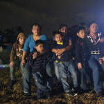 A group of immigrants from Honduras and El Salvador who crossed the U.S.-Mexico border illegally are stopped in Granjeno, Texas, in June. (Eric Gay / Associated Press )